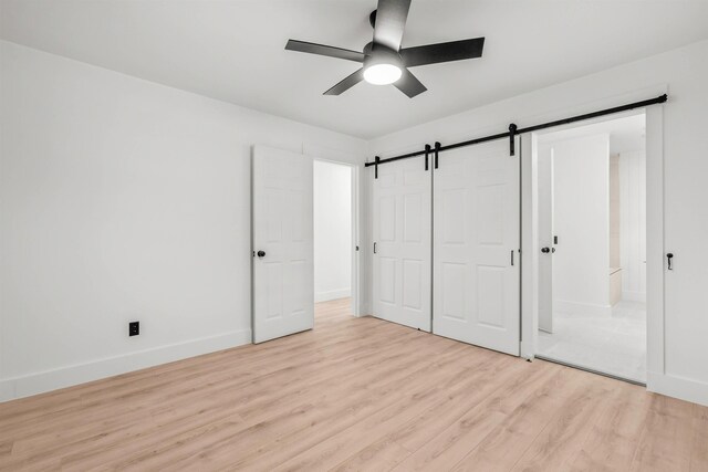 215 Blalock Rd, Boiling Springs, SC 29316 - unfurnished bedroom featuring light wood finished floors, baseboards, a barn door, a closet, and ceiling fan