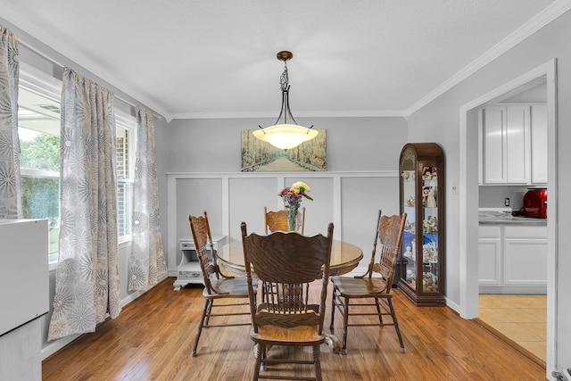 469 Royal Oak, Spartanburg, SC 29302 - dining space featuring crown molding, light wood-type flooring, a decorative wall, a wainscoted wall, and arched walkways