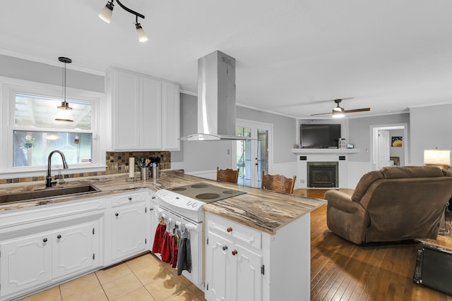 469 Royal Oak, Spartanburg, SC 29302 - kitchen with a sink, extractor fan, a peninsula, white cabinetry, and a glass covered fireplace