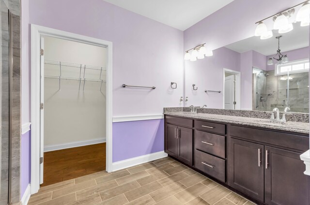 267 Santa Ana, Duncan, SC 29334 - bathroom featuring a stall shower, a spacious closet, double vanity, baseboards, and wood finished floors
