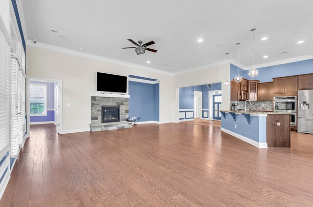 267 Santa Ana, Duncan, SC 29334 - unfurnished living room with a ceiling fan, a stone fireplace, ornamental molding, wood finished floors, and recessed lighting