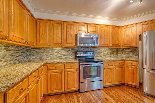 201 Woodridge, Spartanburg, SC 29301 - kitchen featuring stainless steel appliances, light stone counters, light wood-type flooring, brown cabinets, and ornamental molding