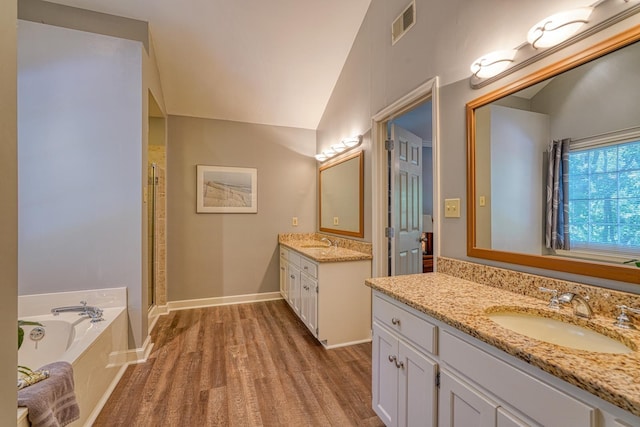201 Woodridge, Spartanburg, SC 29301 - full bathroom featuring wood finished floors, two vanities, a shower stall, a bath, and vaulted ceiling