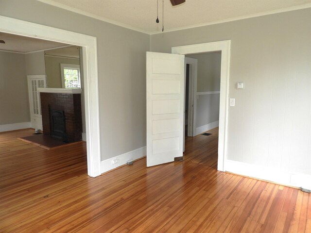 823 W Smith St, Gaffney, SC 29341 - empty room featuring ceiling fan, baseboards, light wood-style floors, ornamental molding, and a fireplace