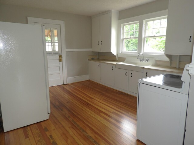 823 W Smith St, Gaffney, SC 29341 - kitchen with freestanding refrigerator, washer / dryer, light wood-style flooring, a sink, and light countertops