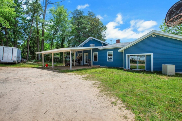1050 W Blackstock, Spartanburg, SC 29301 - back of property featuring driveway, a chimney, a carport, and a lawn