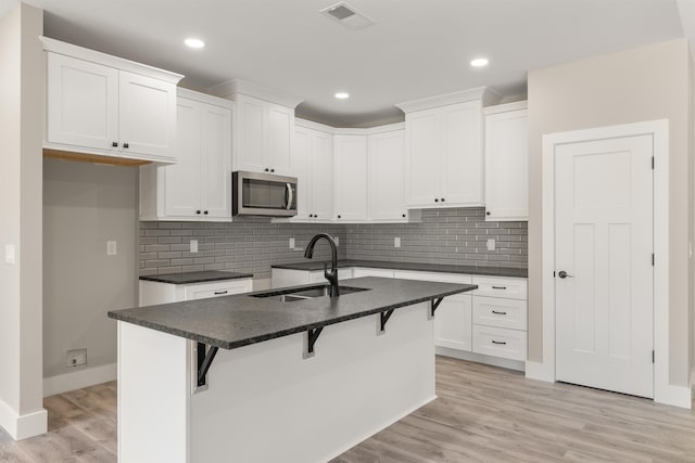 3135 E Croft, Spartanburg, SC 29302 - kitchen featuring stainless steel microwave, a sink, dark countertops, a kitchen breakfast bar, and an island with sink