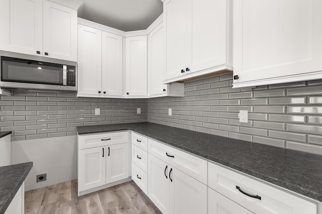 3135 E Croft, Spartanburg, SC 29302 - kitchen with stainless steel microwave, dark stone counters, white cabinets, and tasteful backsplash