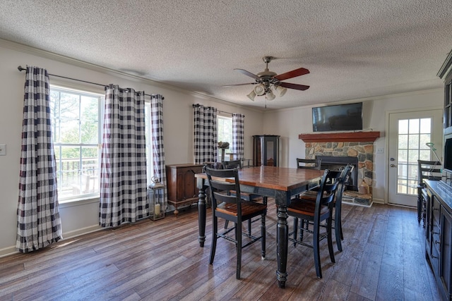 955 Baggett Rd, Enoree, SC 29335 - dining space featuring a stone fireplace, a textured ceiling, dark wood finished floors, ornamental molding, and a ceiling fan