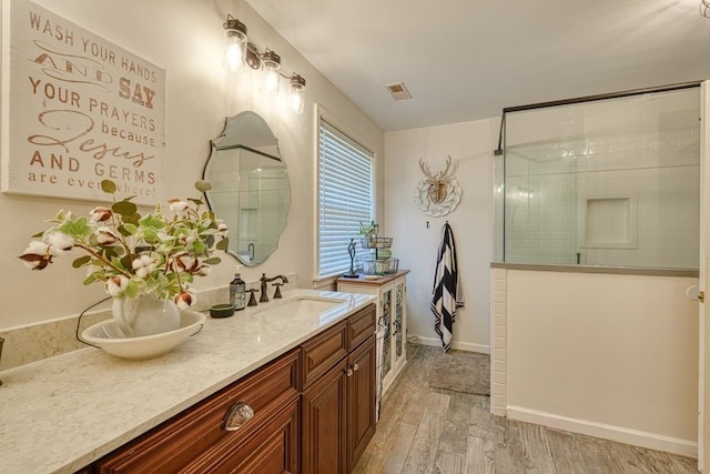 955 Baggett Rd, Enoree, SC 29335 - bathroom featuring tiled shower, wood finished floors, and double vanity
