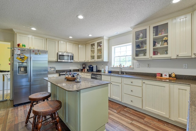955 Baggett Rd, Enoree, SC 29335 - kitchen with appliances with stainless steel finishes, a sink, light wood-type flooring, a textured ceiling, and a center island