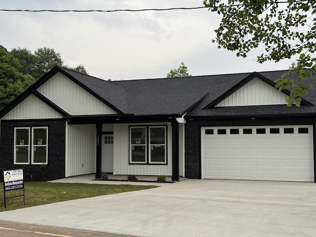 1623 Fairfield, Chesnee, SC 29323 - view of front of house featuring a shingled roof, concrete driveway, a garage, stone siding, and board and batten siding