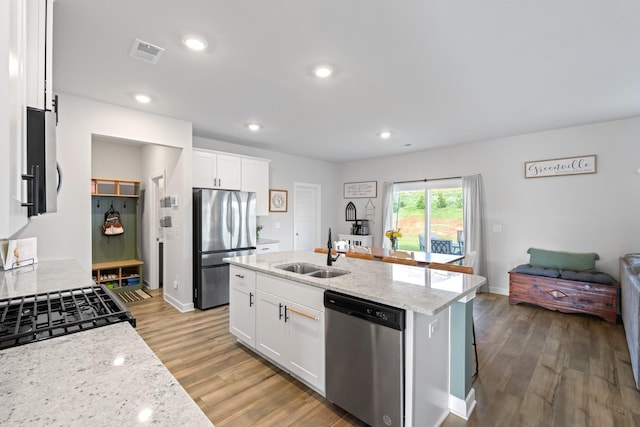 1019 Appalachian, Moore, SC 29369 - kitchen with stainless steel appliances, a sink, wood finished floors, light stone counters, and white cabinetry