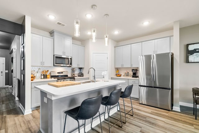 813 Elgon Walk, Fountain Inn, SC 29644 - kitchen featuring stainless steel appliances, a sink, light countertops, backsplash, and light wood-type flooring