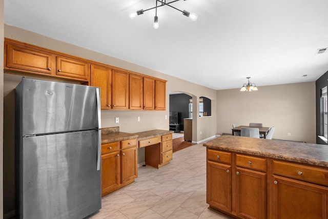 100 Maximus, Greer, SC 29651 - kitchen with freestanding refrigerator, a chandelier, brown cabinetry, and arched walkways