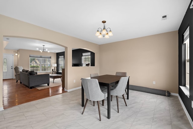 100 Maximus, Greer, SC 29651 - dining room featuring a chandelier, arched walkways, light marble finish floors, and baseboards
