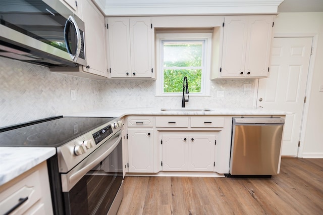 1635 Riveroak Rd, Inman, SC 29349 - kitchen with appliances with stainless steel finishes, a sink, light wood-style floors, and decorative backsplash