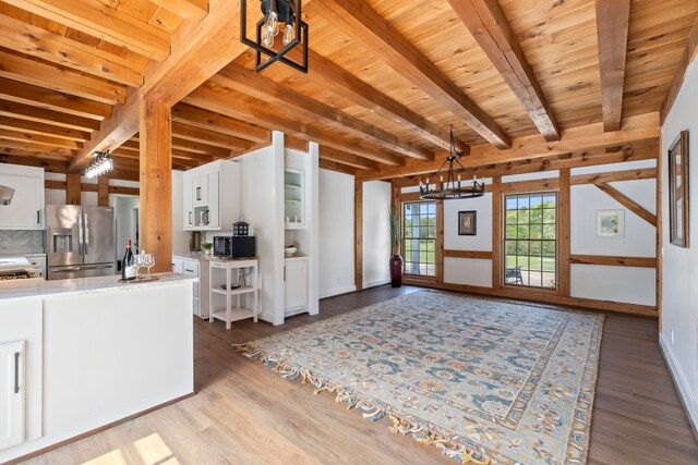 868 Old Hundred, Pelzer, SC 29669 - kitchen with stainless steel refrigerator with ice dispenser, black microwave, white cabinets, wood finished floors, and wood ceiling with exposed beams