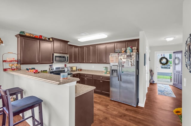 651 Willow Bank, Moore, SC 29369 - kitchen with stainless steel appliances, dark brown cabinetry, wood finished floors, a kitchen breakfast bar, and a peninsula