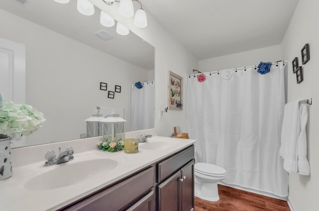 651 Willow Bank, Moore, SC 29369 - bathroom featuring wood finished floors, double vanity, toilet, and a shower with shower curtain