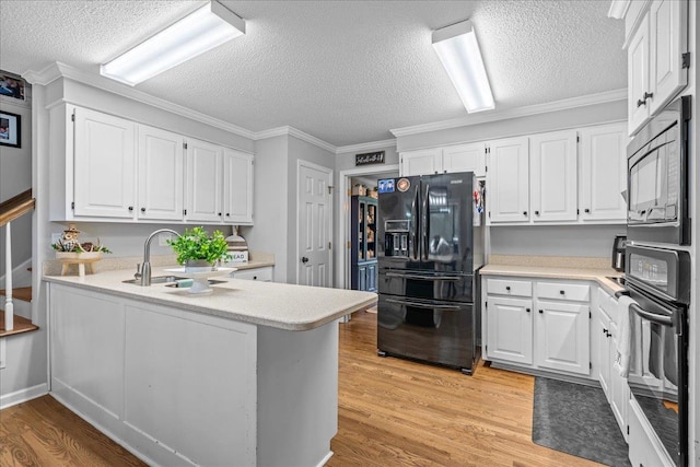 805 Laurel, Spartanburg, SC 29301 - kitchen with black appliances, a sink, white cabinets, light wood-style floors, and a textured ceiling