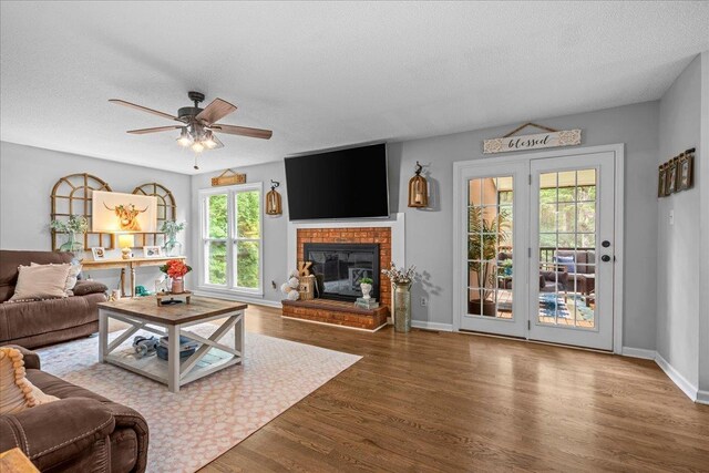 805 Laurel, Spartanburg, SC 29301 - living area featuring a textured ceiling, wood finished floors, a ceiling fan, a brick fireplace, and baseboards