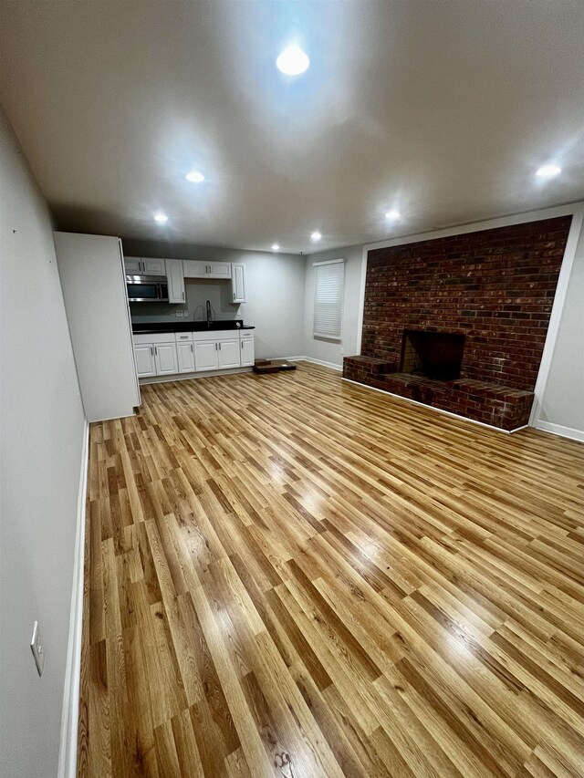 805 Laurel, Spartanburg, SC 29301 - unfurnished living room with light wood finished floors, a sink, baseboards, recessed lighting, and a fireplace