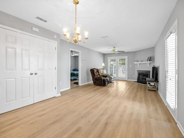 1156 Webber, Spartanburg, SC 29307 - living area featuring light wood-style flooring, a ceiling fan, a chandelier, a fireplace, and a textured ceiling