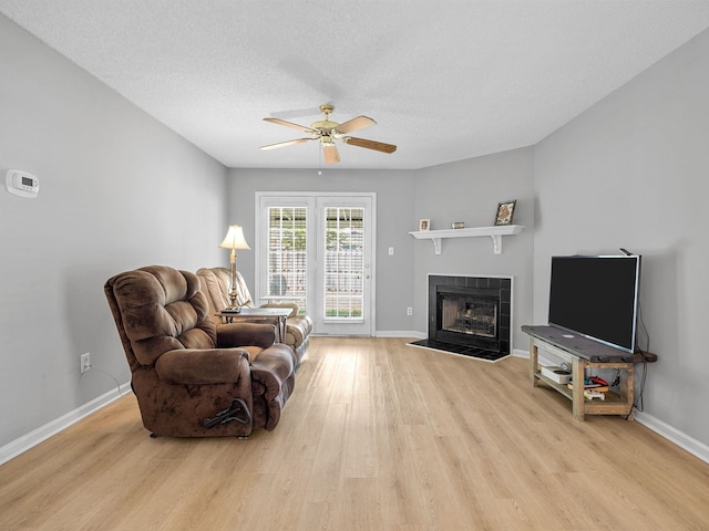 1156 Webber, Spartanburg, SC 29307 - living area featuring light wood finished floors, ceiling fan, a tile fireplace, baseboards, and a textured ceiling