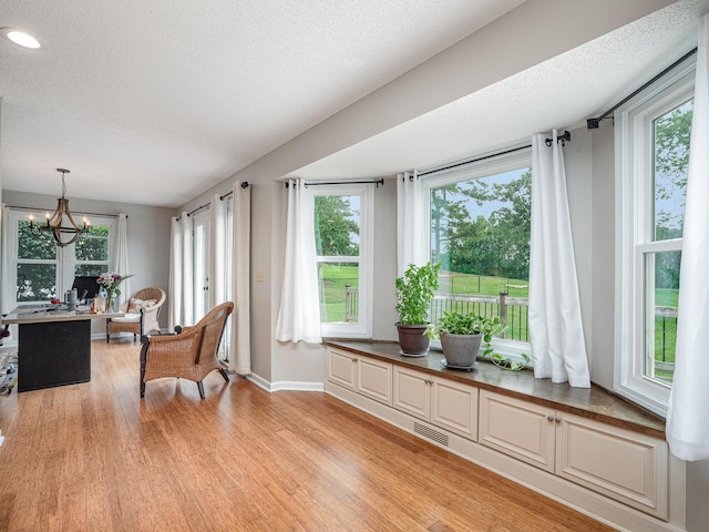 760 Three Wood, Woodruff, SC 29388 - living area with healthy amount of natural light, light wood-style flooring, baseboards, a chandelier, and a textured ceiling