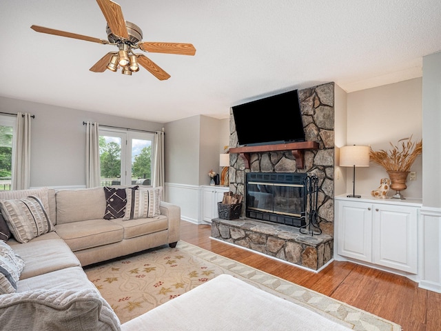 760 Three Wood, Woodruff, SC 29388 - living room featuring light wood-style floors, a stone fireplace, and a ceiling fan