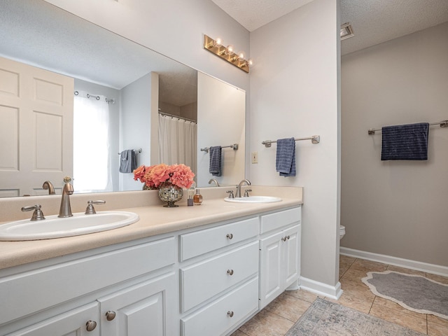 760 Three Wood, Woodruff, SC 29388 - bathroom featuring double vanity, toilet, tile patterned floors, a textured ceiling, and baseboards