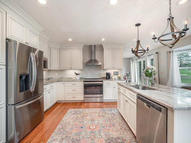 760 Three Wood, Woodruff, SC 29388 - kitchen with appliances with stainless steel finishes, wall chimney range hood, a sink, a chandelier, and light wood-type flooring