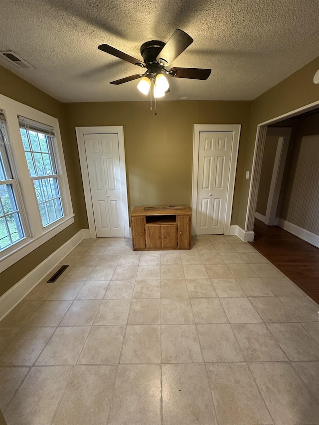 221 Mill, Gaffney, SC 29341 - unfurnished bedroom featuring a textured ceiling, baseboards, light tile patterned floors, and ceiling fan