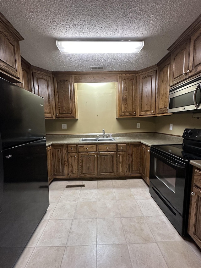 221 Mill, Gaffney, SC 29341 - kitchen with black appliances, a sink, a textured ceiling, light tile patterned floors, and light countertops