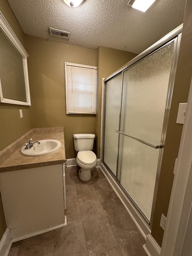221 Mill, Gaffney, SC 29341 - bathroom featuring vanity, toilet, a textured ceiling, a stall shower, and baseboards