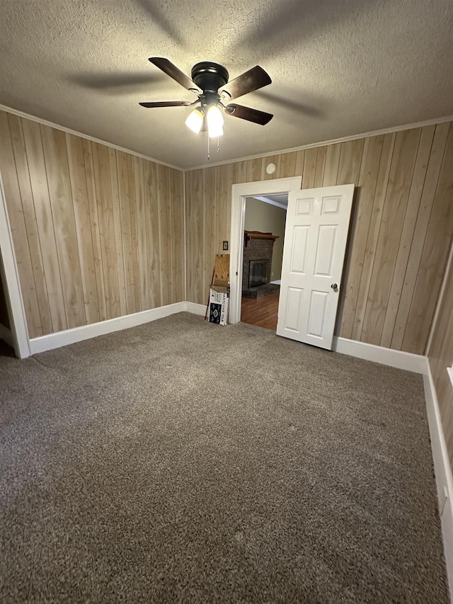 221 Mill, Gaffney, SC 29341 - spare room with ceiling fan, wood walls, carpet, a textured ceiling, and baseboards