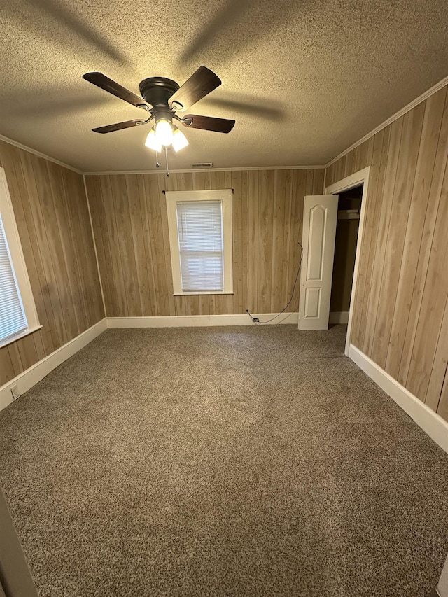 221 Mill, Gaffney, SC 29341 - carpeted empty room featuring a ceiling fan, wooden walls, a textured ceiling, and crown molding