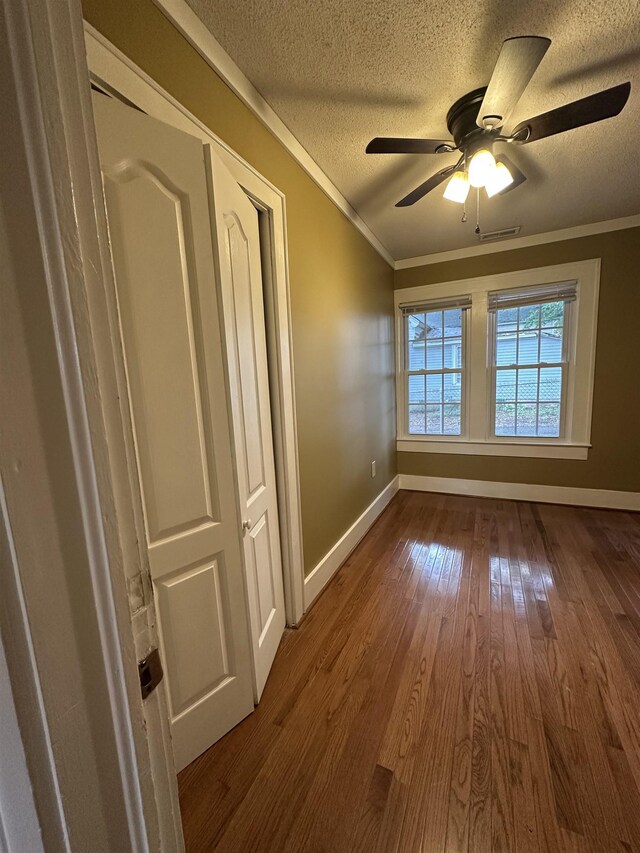 221 Mill, Gaffney, SC 29341 - unfurnished room with a textured ceiling, baseboards, dark wood-style flooring, crown molding, and a ceiling fan