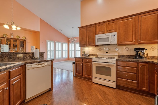427 Listrac, Moore, SC 29369 - kitchen featuring white appliances, a chandelier, high vaulted ceiling, dark countertops, and brown cabinetry