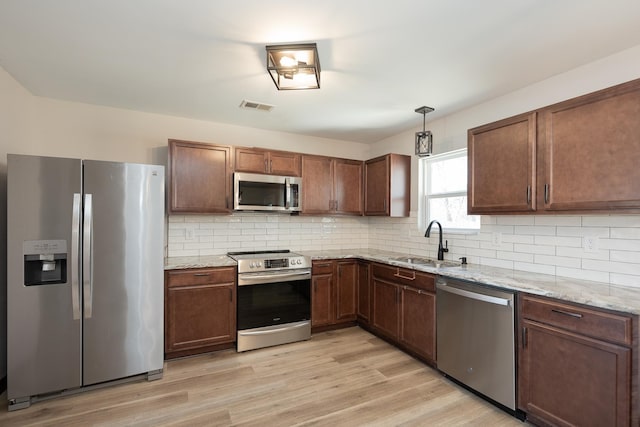 170 Old Timber, Woodruff, SC 29388 - kitchen featuring stainless steel appliances, a sink, light wood-type flooring, and backsplash