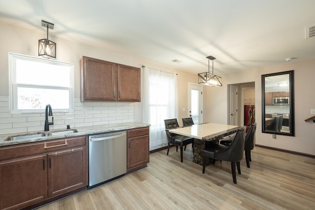 170 Old Timber, Woodruff, SC 29388 - kitchen featuring appliances with stainless steel finishes, a sink, washer and dryer, light wood-type flooring, and backsplash