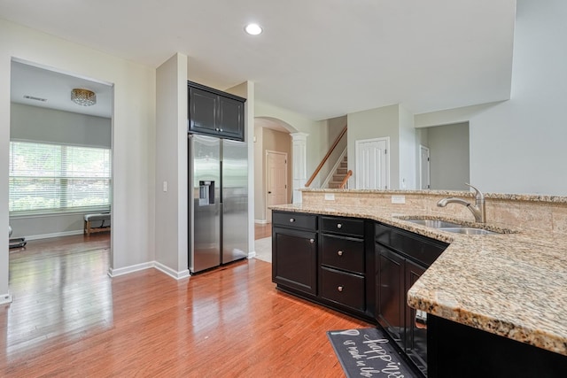 514 Millervale, Greer, SC 29650 - kitchen featuring stainless steel fridge with ice dispenser, a sink, light wood-style floors, arched walkways, and light stone counters