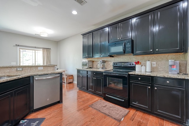 514 Millervale, Greer, SC 29650 - kitchen with black appliances, dark cabinetry, light wood-style floors, tasteful backsplash, and light stone counters