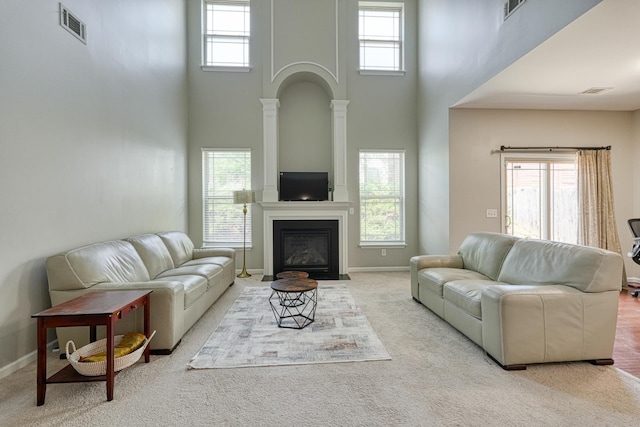 514 Millervale, Greer, SC 29650 - living room featuring a high ceiling, healthy amount of natural light, carpet flooring, baseboards, and a large fireplace