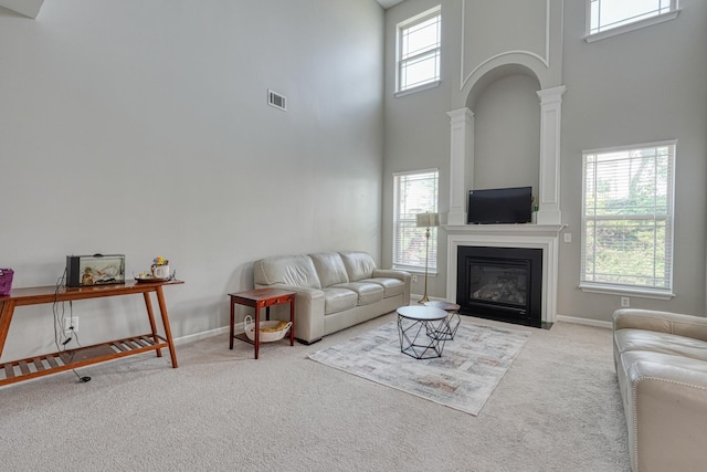 514 Millervale, Greer, SC 29650 - carpeted living area with a high ceiling, decorative columns, a fireplace with flush hearth, and baseboards