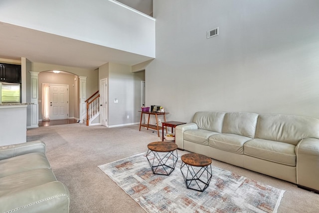 514 Millervale, Greer, SC 29650 - living room featuring arched walkways, light colored carpet, ornate columns, stairs, and a towering ceiling