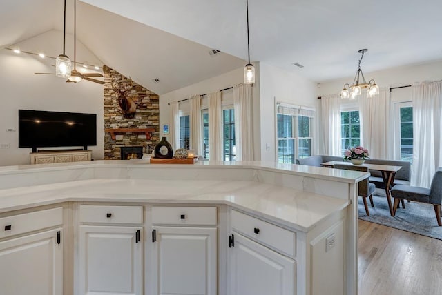 355 Night Lark, Campobello, SC 29322 - kitchen featuring a ceiling fan, light wood-style flooring, a fireplace, light stone countertops, and open floor plan
