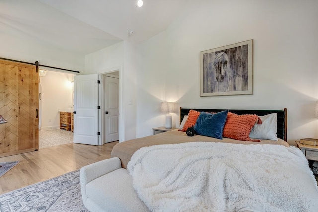 355 Night Lark, Campobello, SC 29322 - bedroom featuring wood finished floors, a barn door, high vaulted ceiling, connected bathroom, and baseboards