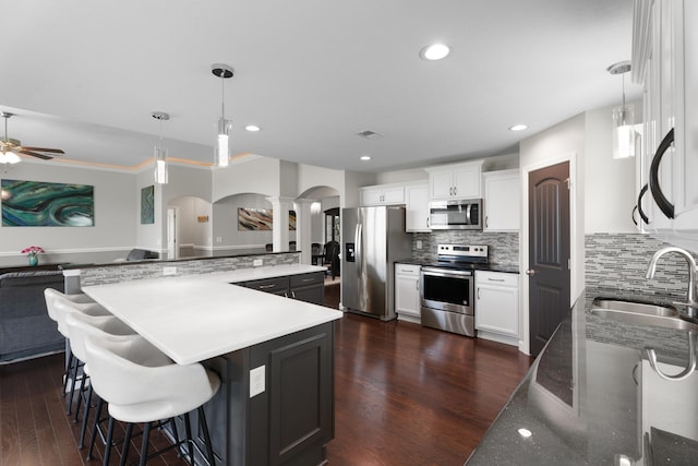 309 Old Kimbrell, Boiling Springs, SC 29316 - kitchen featuring appliances with stainless steel finishes, arched walkways, a sink, decorative columns, and ceiling fan